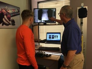 Maggs walking a young athlete through a Structural Fingerprint Exam