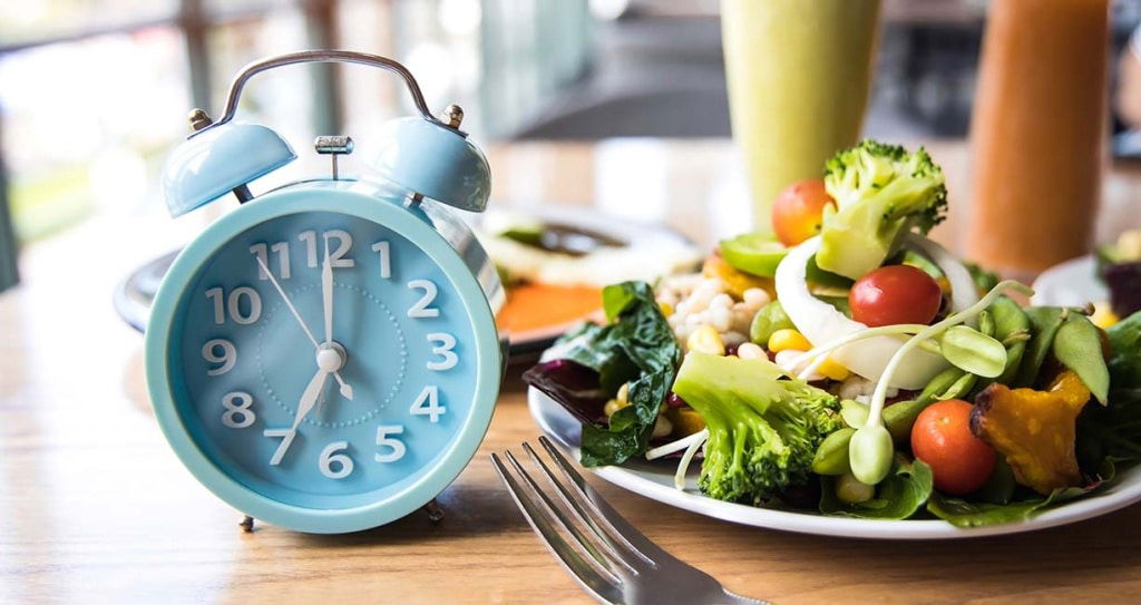 Selective focus with Blue clock breakfast time and Intermittent fasting ,Lifestyle concept.